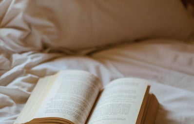 book with glasses on bed