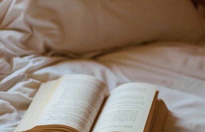book with glasses on bed