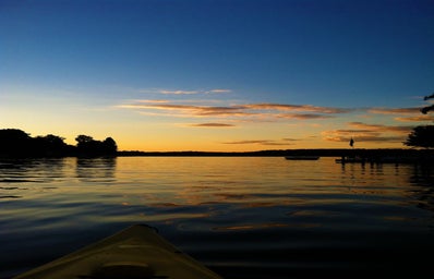 kayaking along a lake during sunset