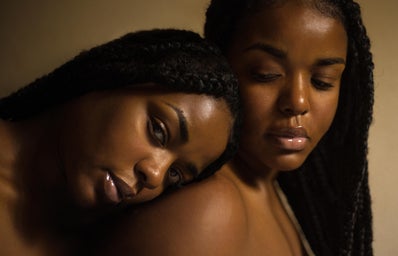 two Black women with one leaning her head on the other