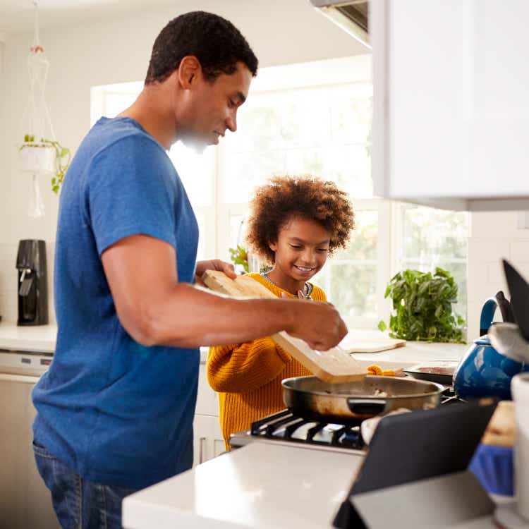 Father and daughter cooking food in kitchen