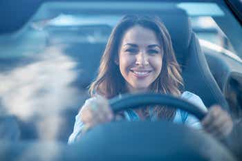 Woman driving a convertible and smiling