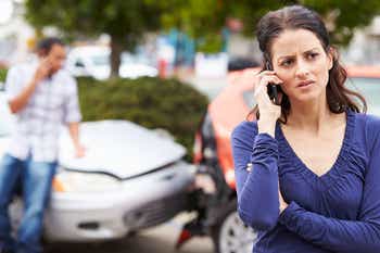 Woman on phone after her car was rear ended 