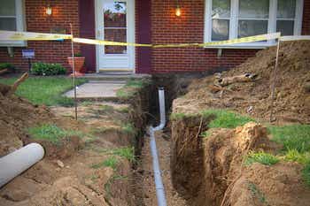 Front yard dug up revealing service lines from street to house