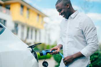 Businessman charging electric car