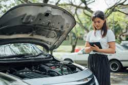 Automobile insurance adjuster using digital tablet to inspecting damage to vehicle.