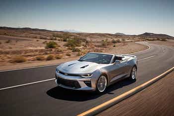 Silver convertible Camaro driving through the desert