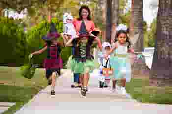 Parent taking children trick or treating at Halloween