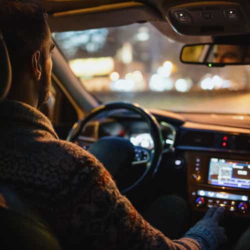 Man driving car in the city streets at night