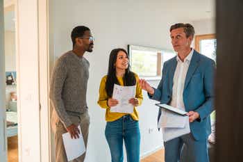 Future house owners indoors doing a visit with a real estate agent