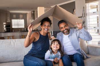 Happy family with child holding cardboard roof