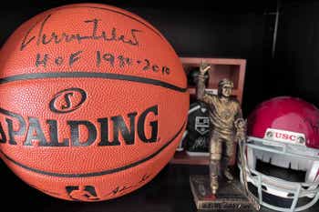 Signed basketball, Gretzky trophy, USC helmet and sports memorabilia on a shelf