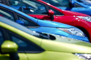 A line of colorful cars parked at a car dealer