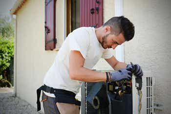 Technician working on outdoor air conditioning unit