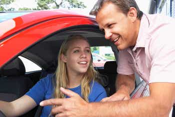 Dad talking to daughter before she drives her car