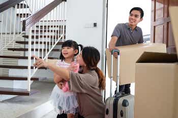 Portrait of happy Asian family moving into new home