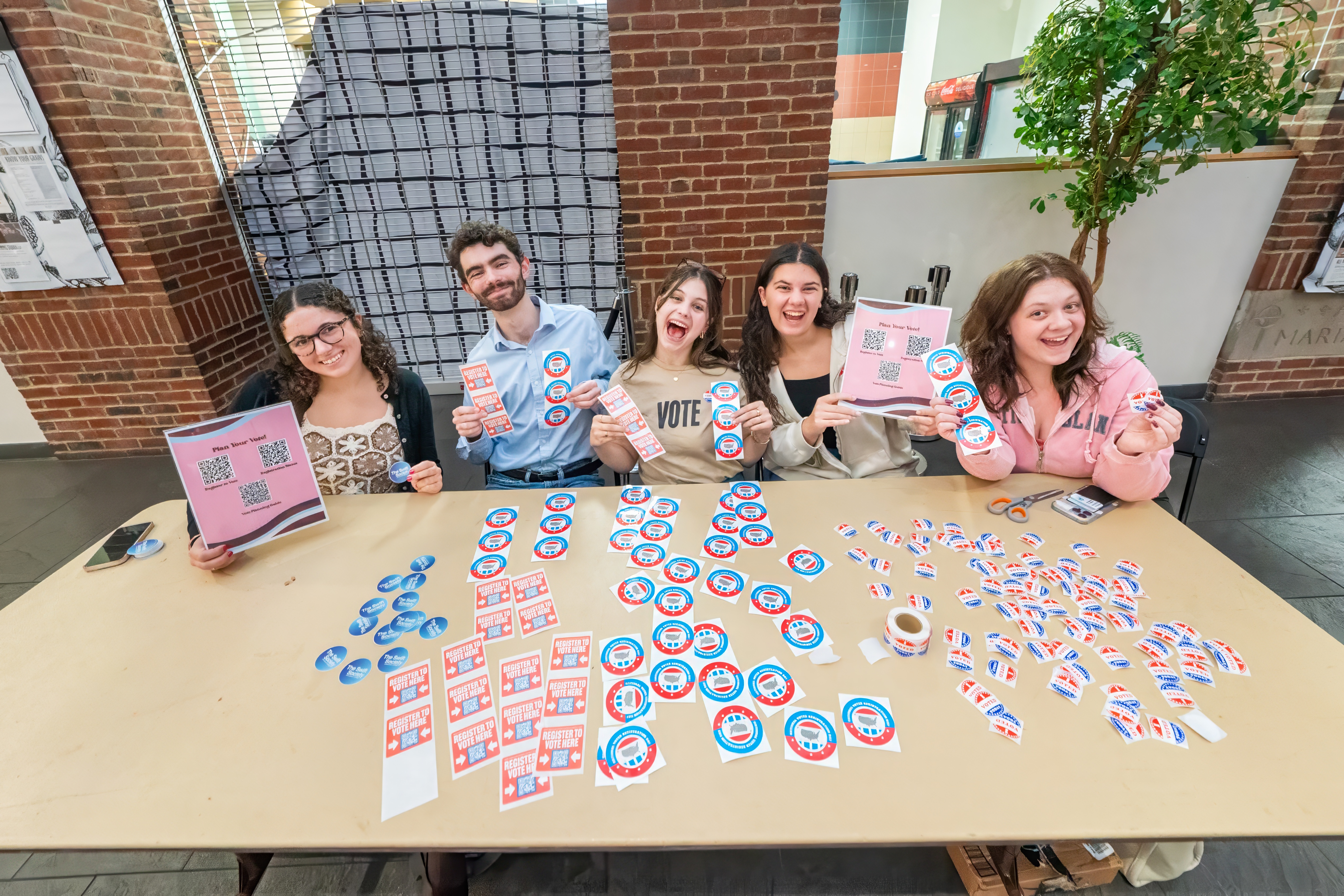 A group of students at a voter registration drive table 