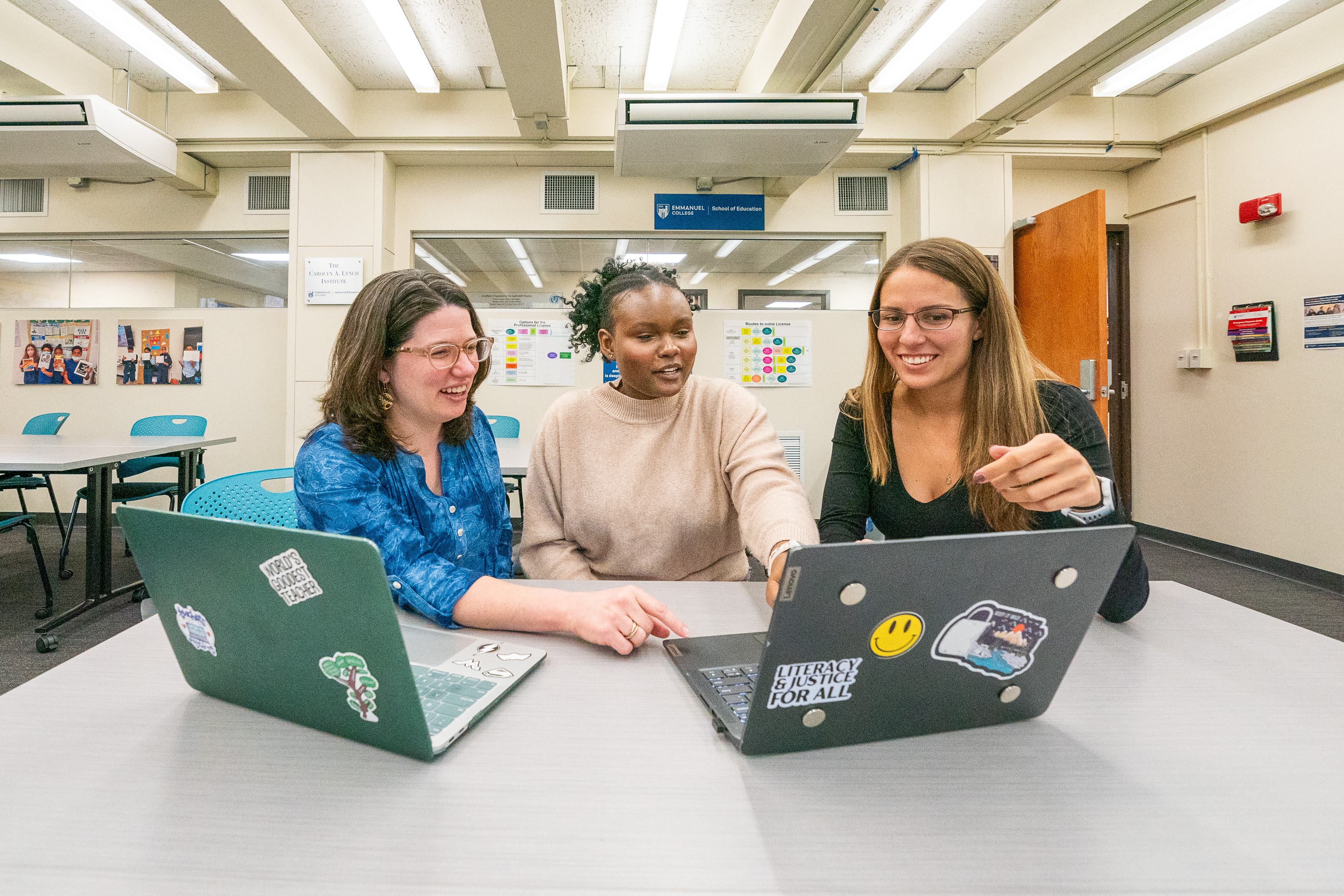 three people looking at a laptop together 