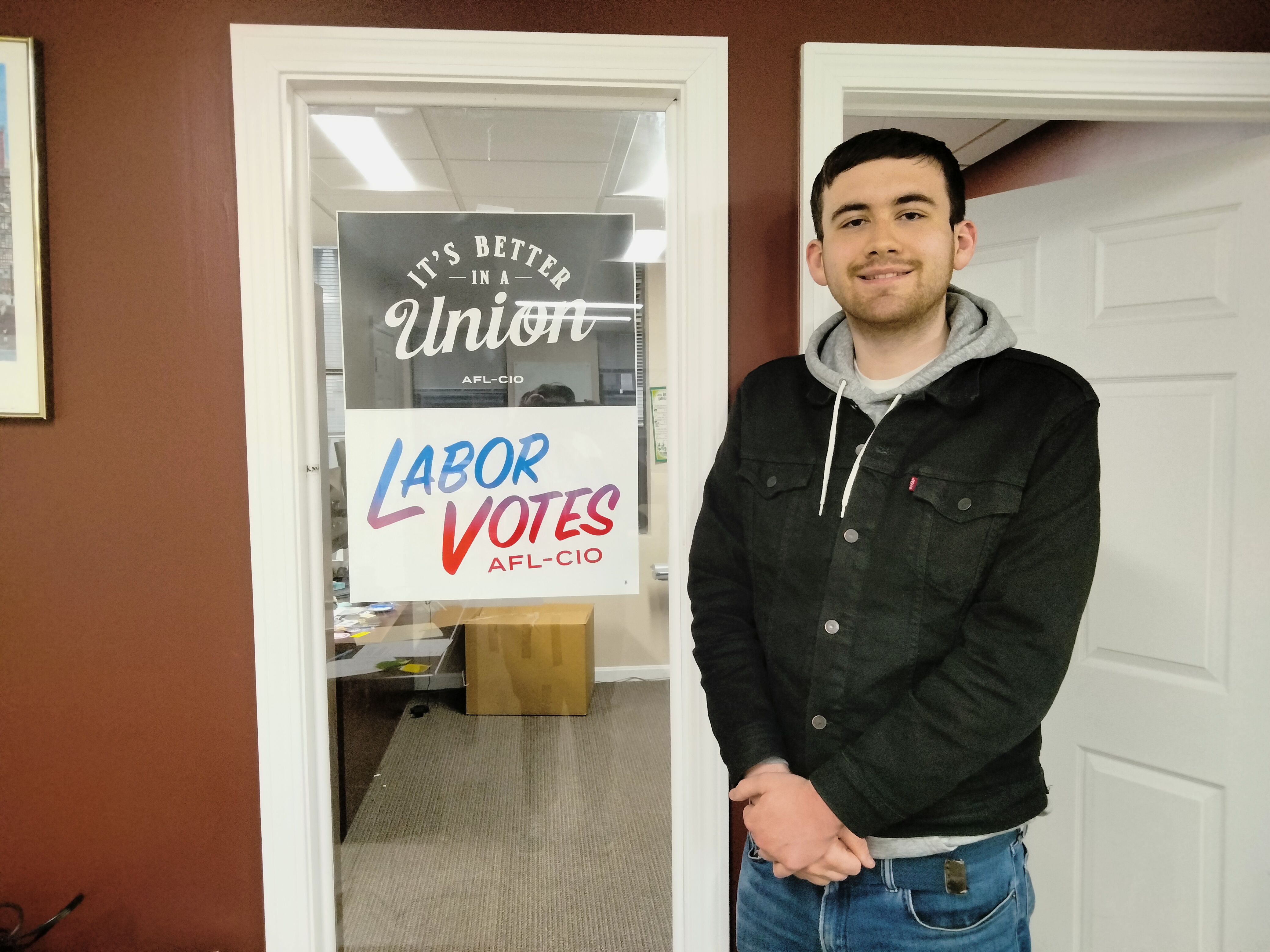 A young man wearing a black jacket outside the AFL-CIO offices 