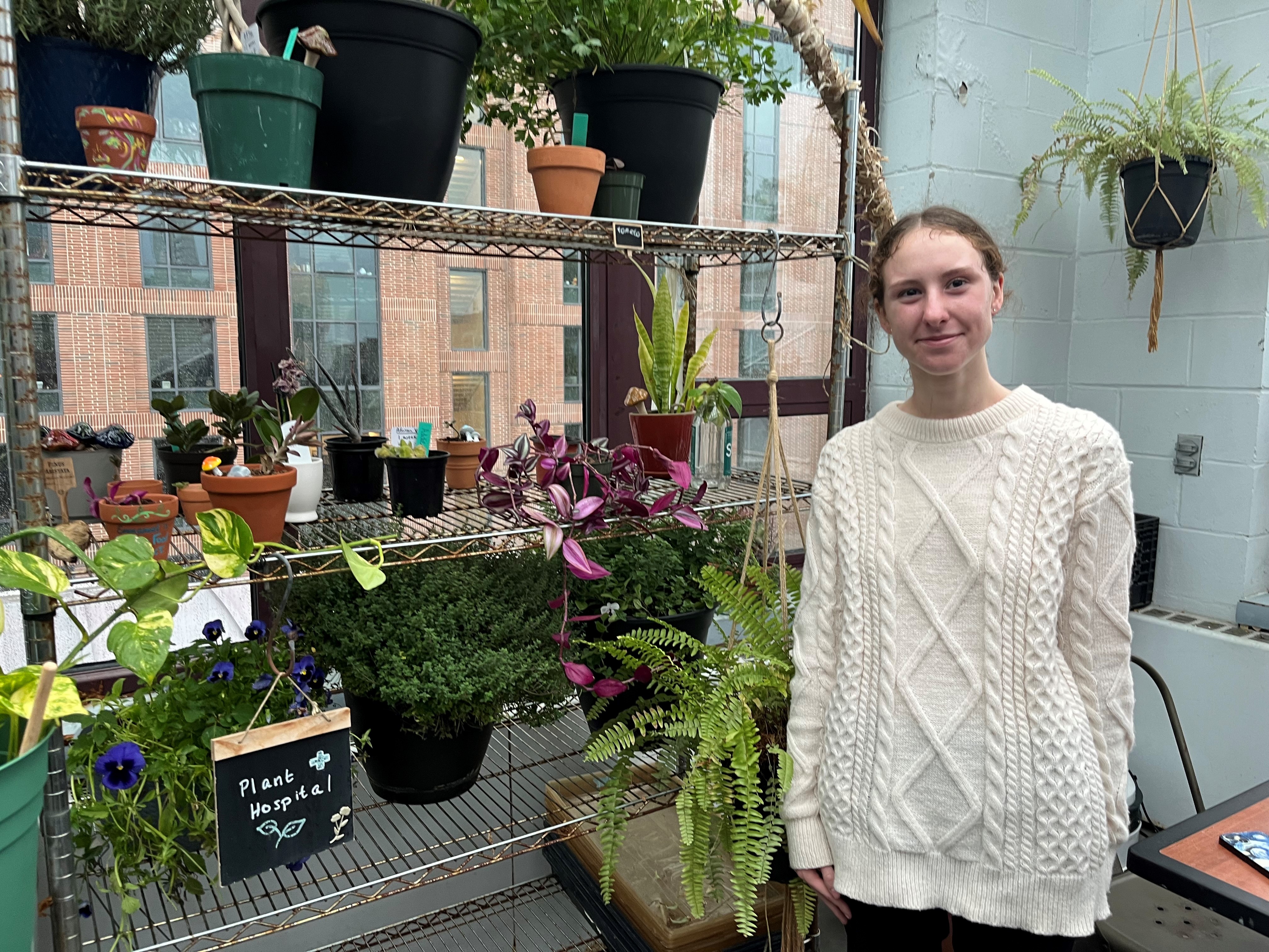 An Emmanuel student with the plant hospital in the campus greenhouse 