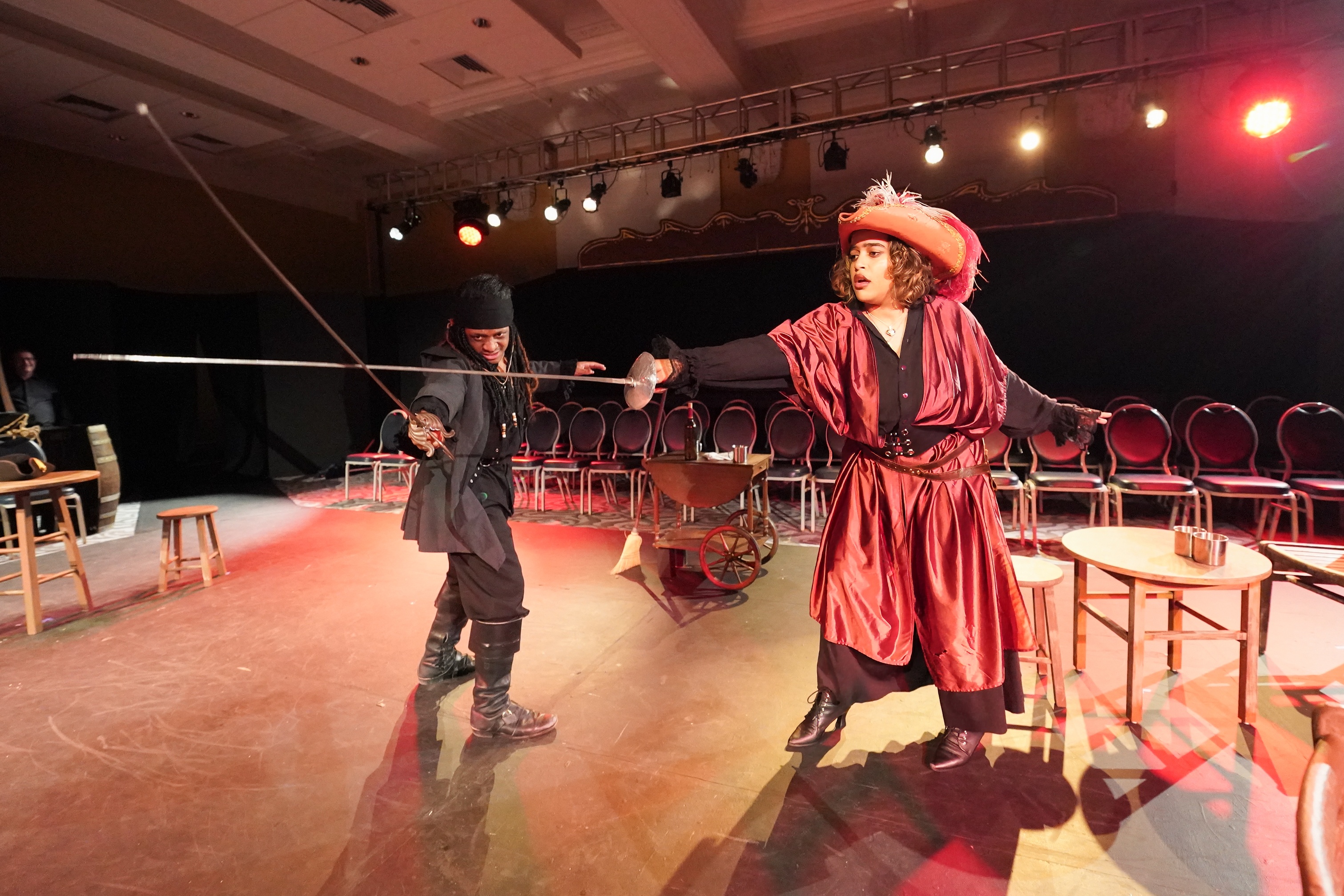 Two students cross swords as part of a drama production 