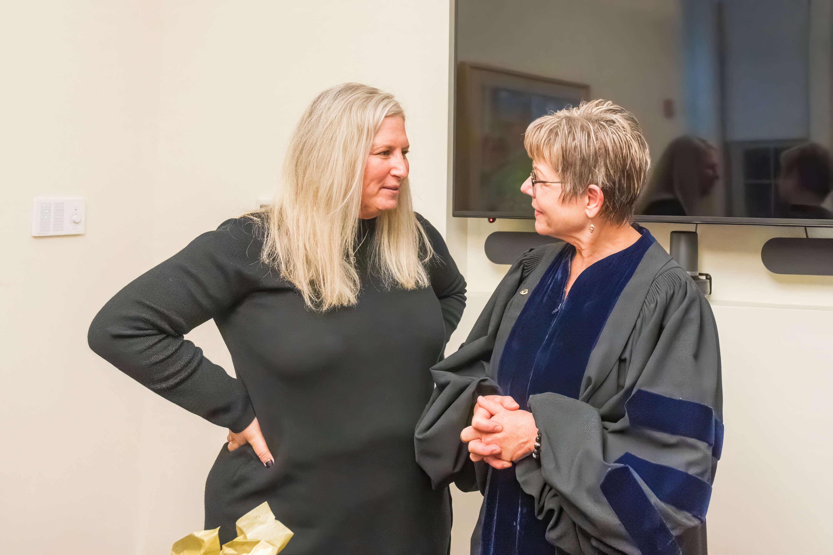 A recent graduate and professor having a discussion 