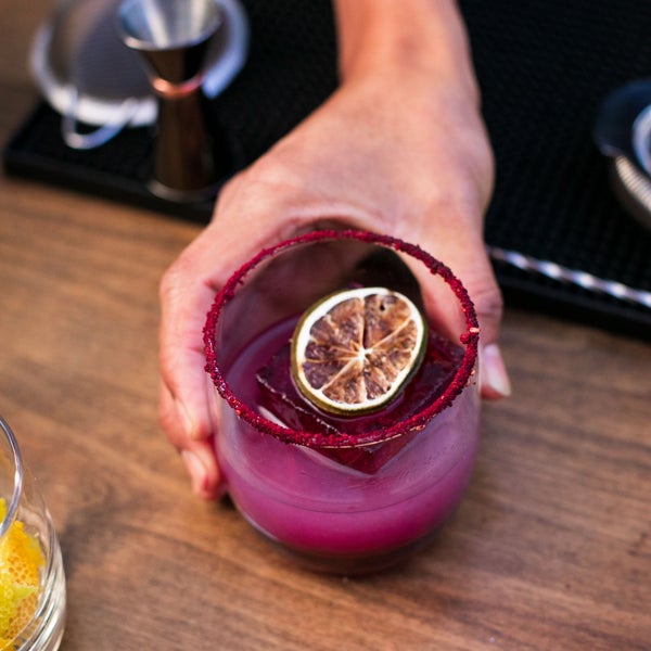 A purple cocktail with a red rim