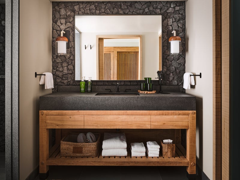 A bathroom with necessary amenities stocked on the shelf