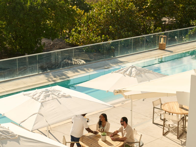 people sitting at table by pool