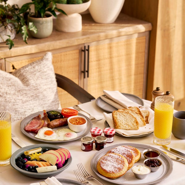 A spread of breakfast dishes in a warmly lit hotel room