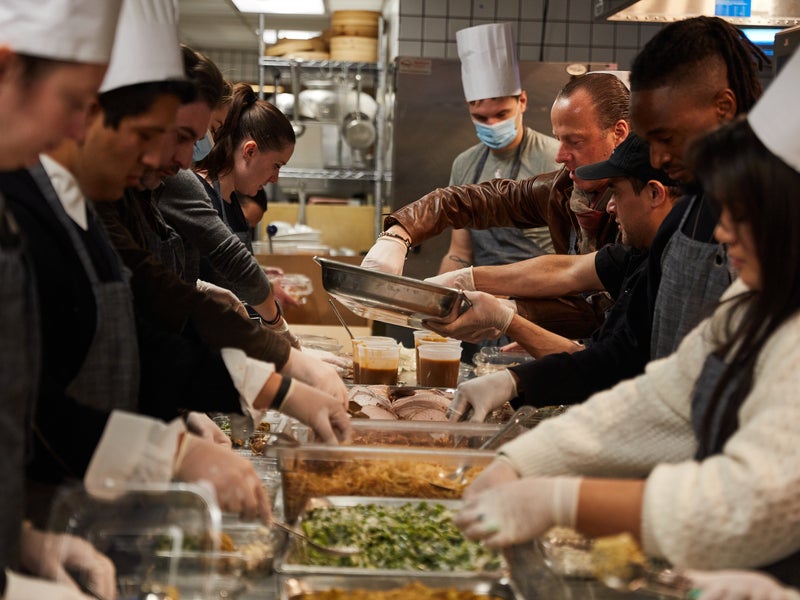 Two rows of people helping to prepare food