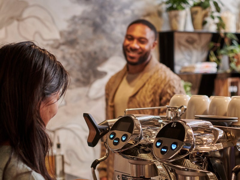 Person making coffee for a customer