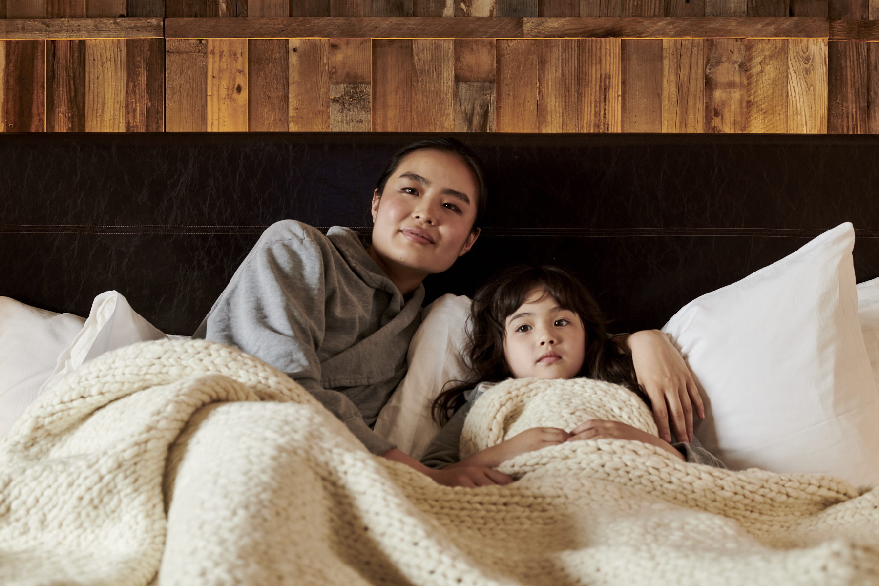 Mother and daughter lounge in their bed