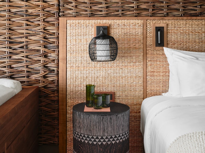 A decorative side table sits in front of a rustic wooden backdrop