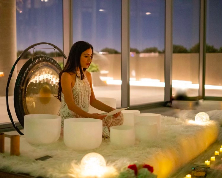 Person sitting on a blanket reading from a piece of paper