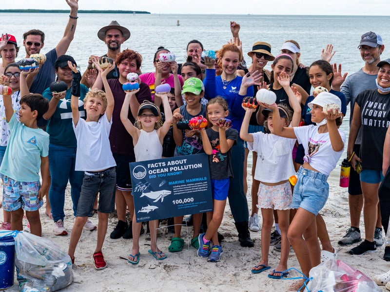 A group of people posing for a photo after cleaning a beach of trash
