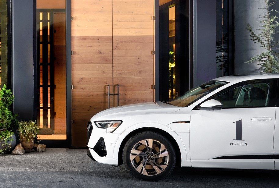 a white car with a 1hotels decal stopped next to a building