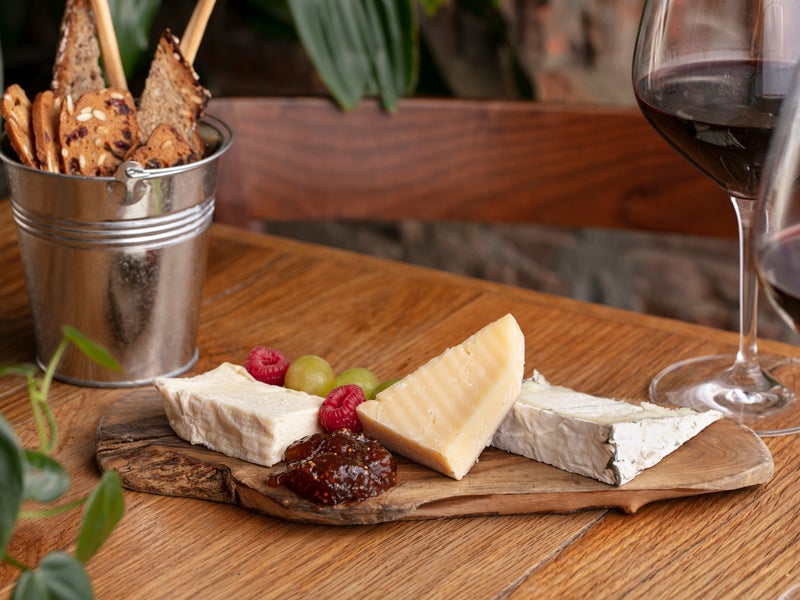 A cheeseboard with fruit and wine