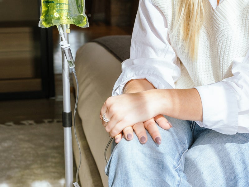 Person sitting cross-legged getting an IV infusion