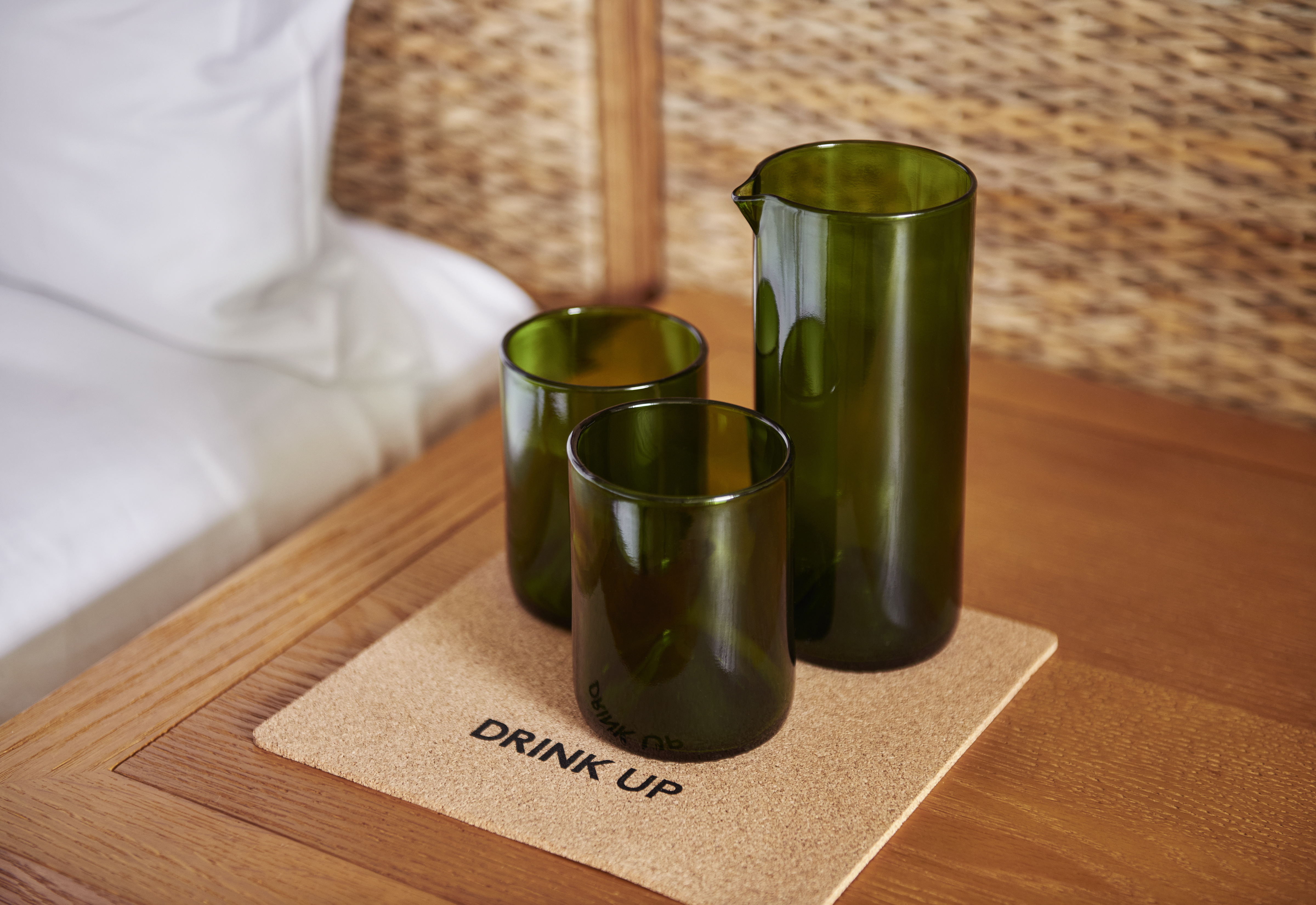 Three green glasses on a cork coaster