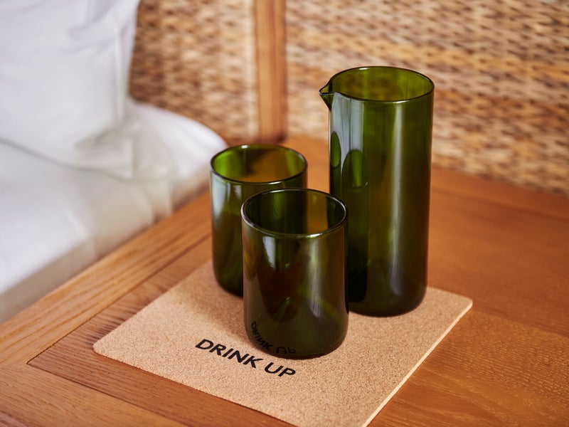 Three green glasses on a cork coaster