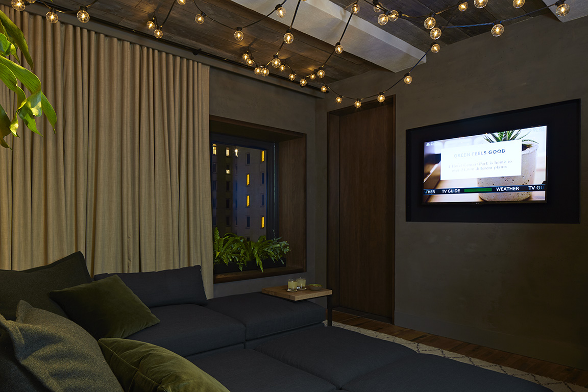 Dimly lit room with a large couch and wall mounted tv