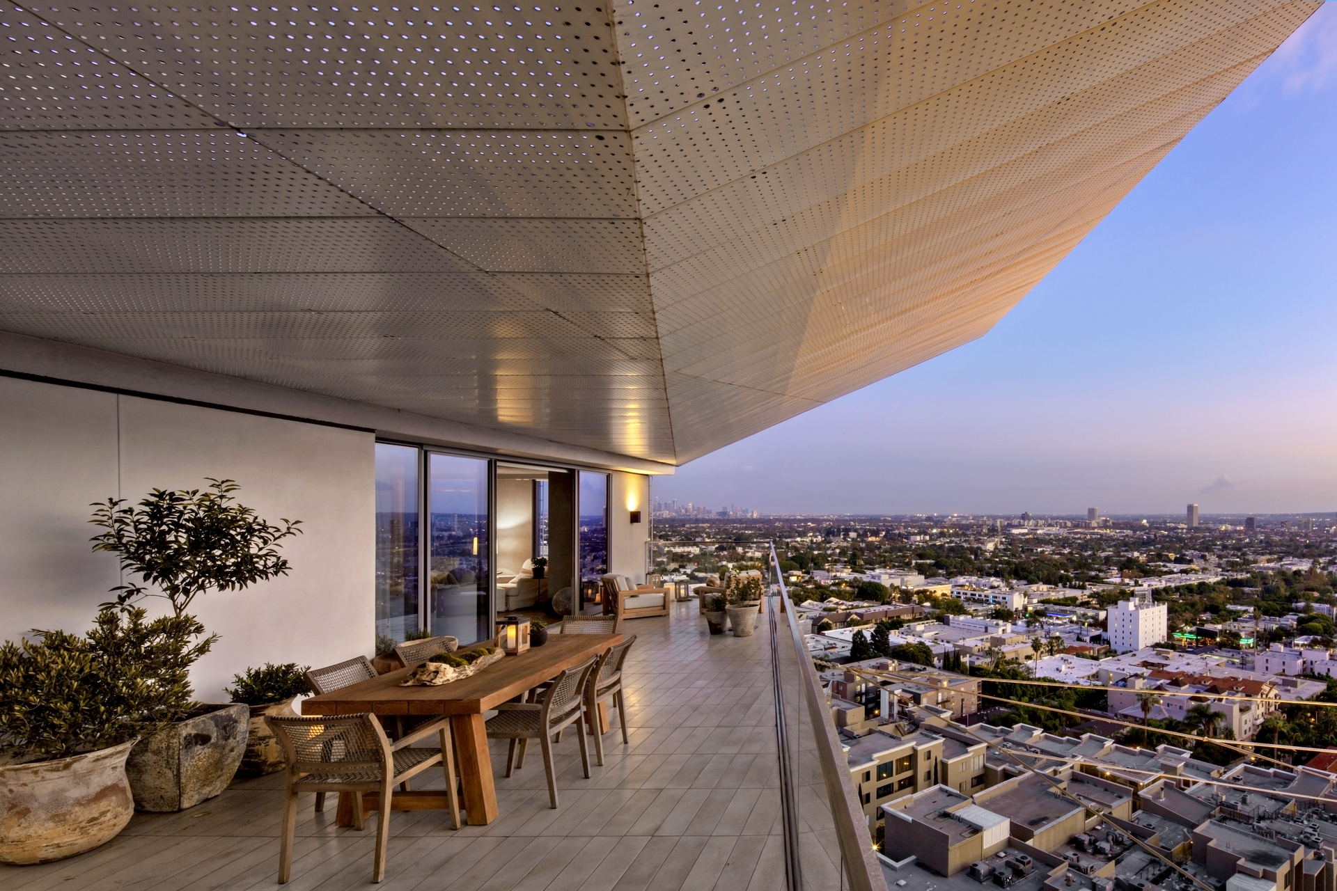 Een hoog balkon met een tafel en stoelen