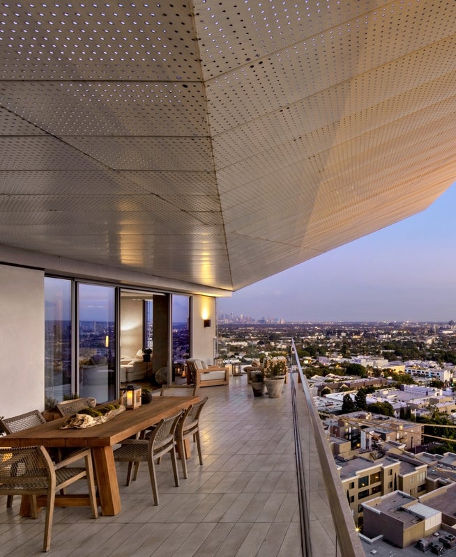A high up balcony with a table and chairs