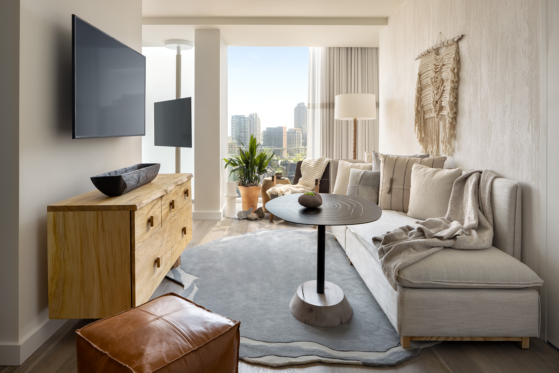 Narrow living room area with high coffee table and wooden dresser