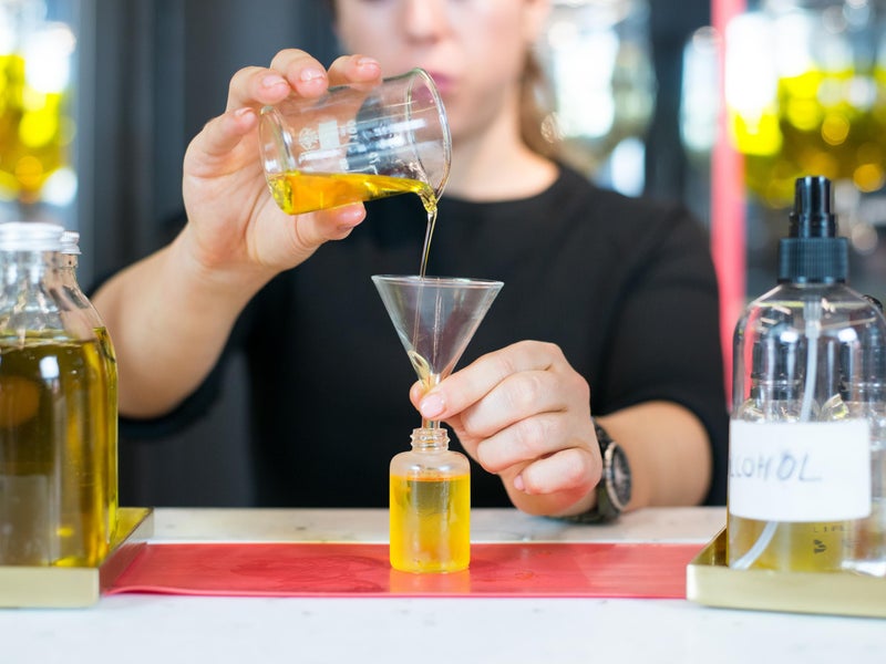 Bartender pouring yellow liquid into funnel