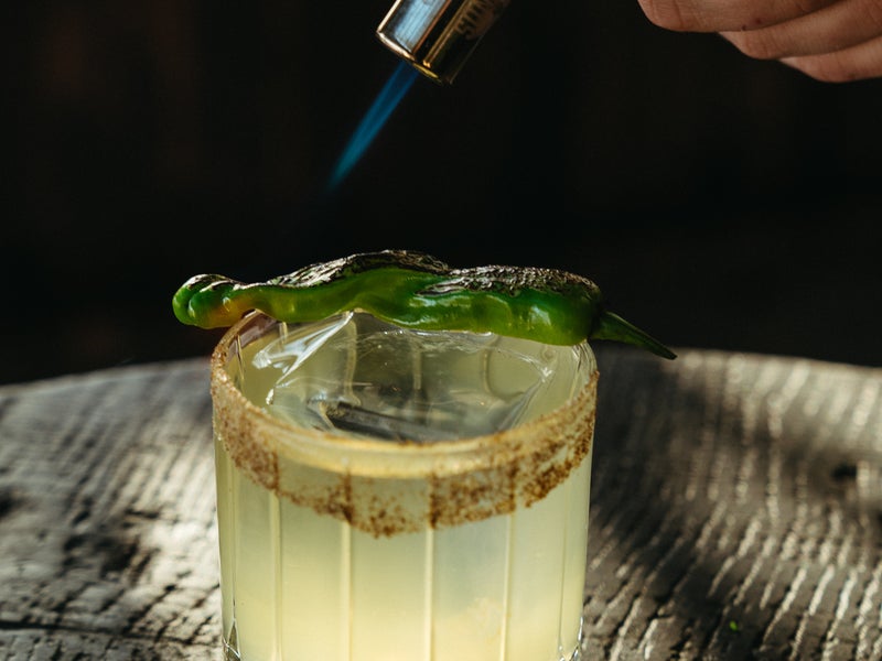 A cocktail getting toasted with a blowtorch