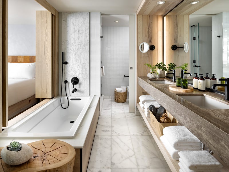 Long narrow bathroom with double sinks and a bathtub