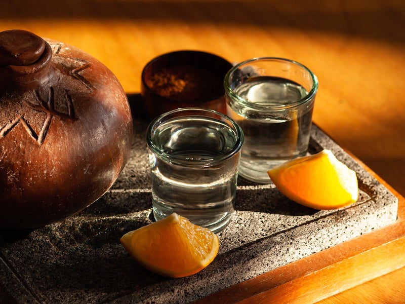 Two glasses of mezcal with an orange slice