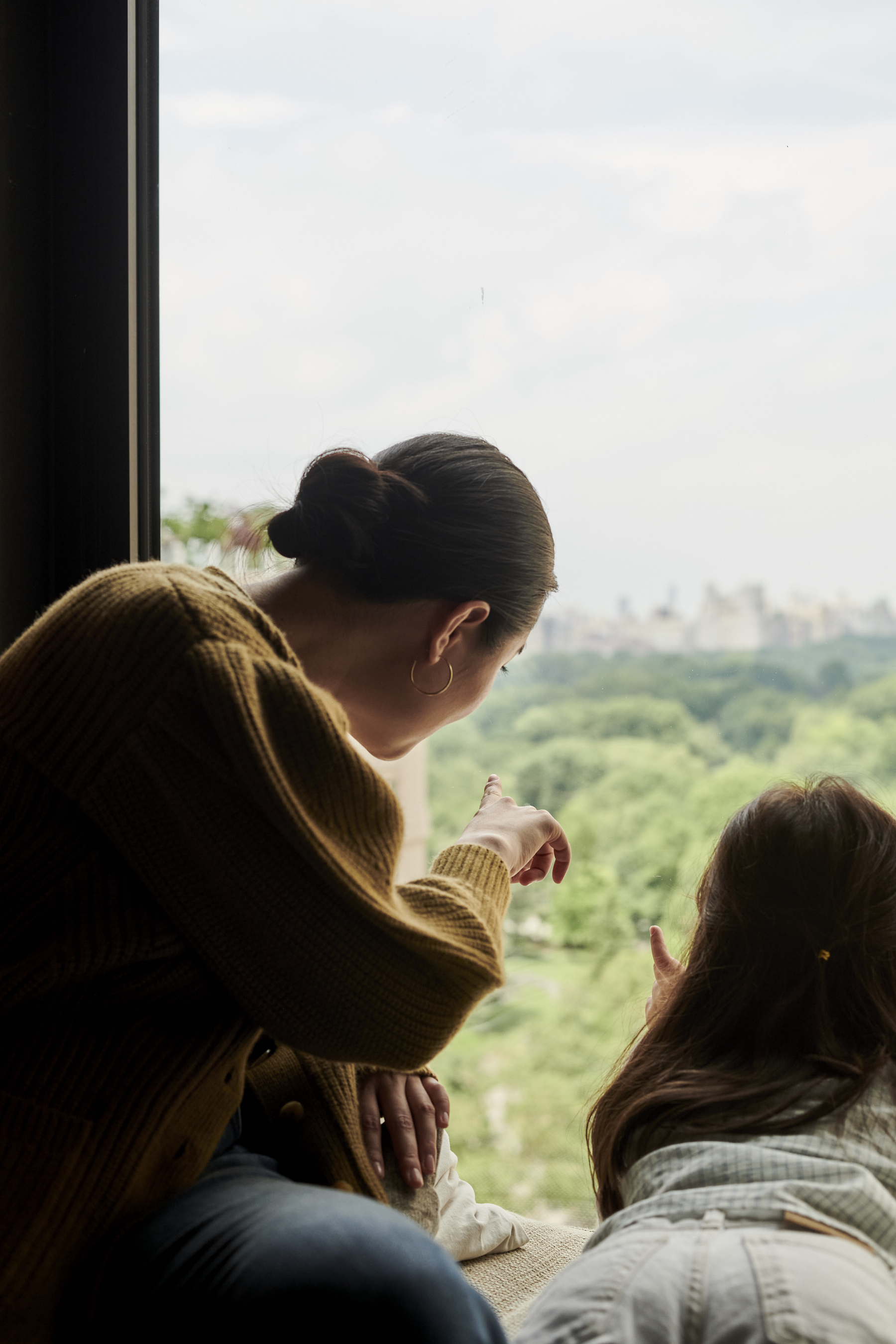Maman et sa fille surplombant Central Park depuis leur chambre d'hôtel